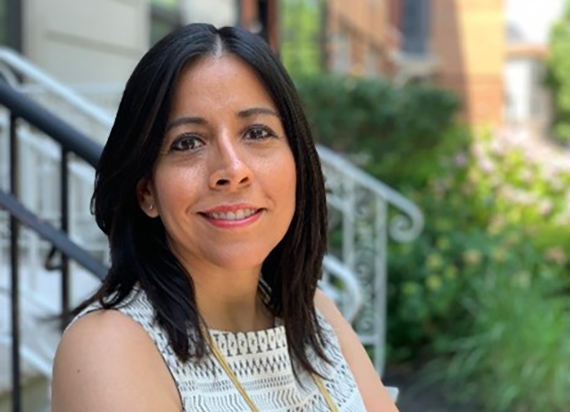 A headshot of Michelle Sanchez smiling against an outdoor background.